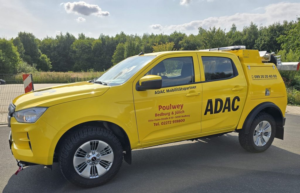 Gelber Truck mit der Aufschrift "ADAC" auf der Seite.