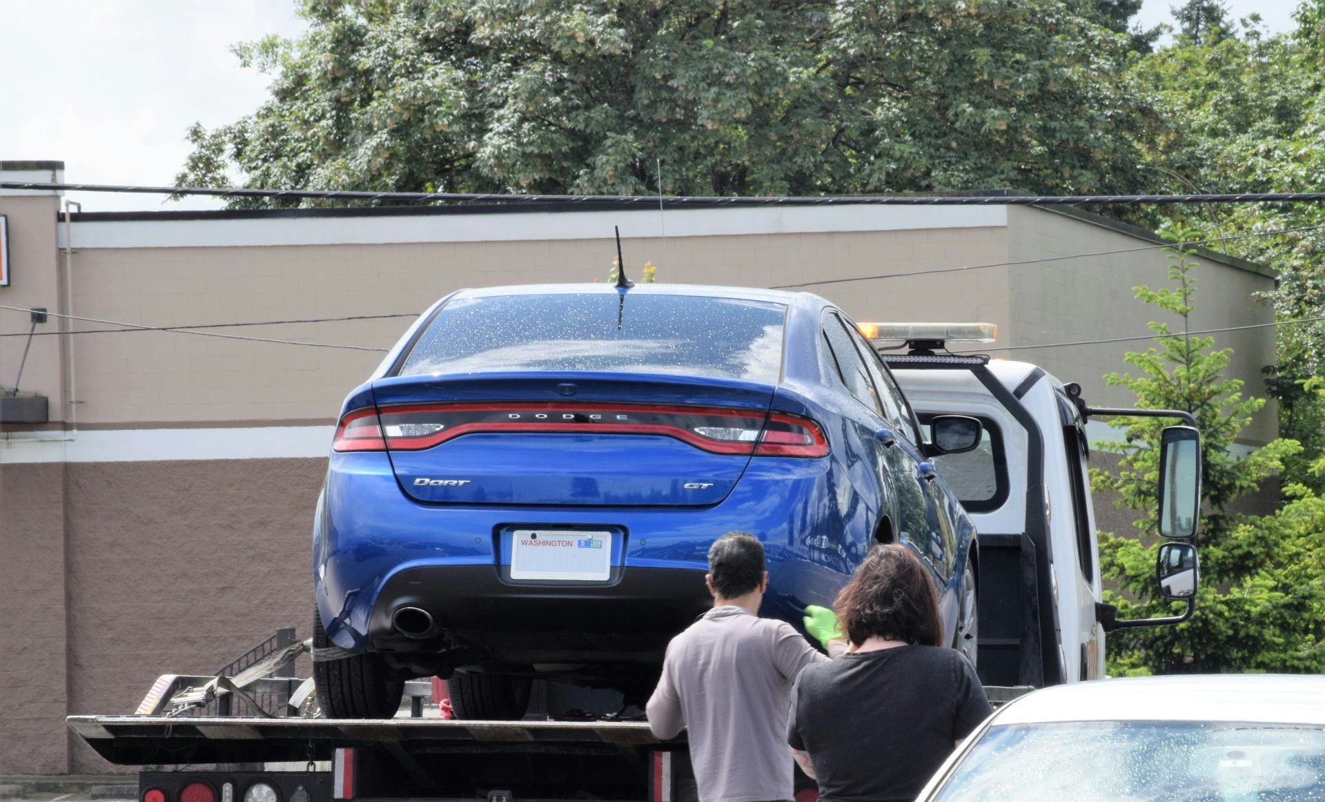 Ein blaues Auto wird auf einen Pritschenwagen verladen.